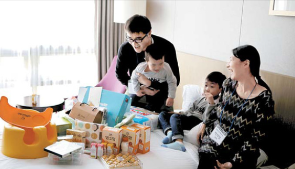 자녀와 함께 매일유업 베이비문에 참석한 가족이 임신 축하 선물을 보며 즐거워하고 있다. [사진 매일유업]